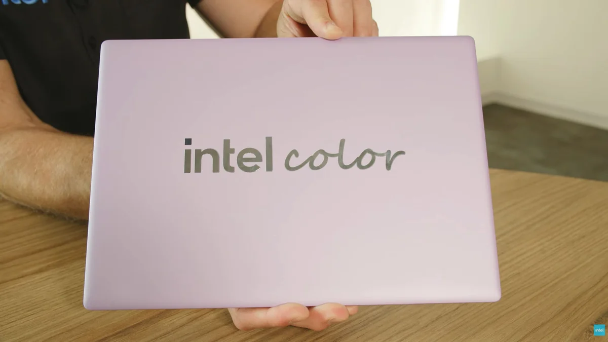 A person holds a lavender-colored laptop with the text 'intel color' on the lid.