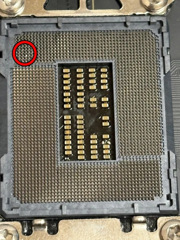 A close-up of a CPU socket on a motherboard shows a bent pin highlighted with a red circle.