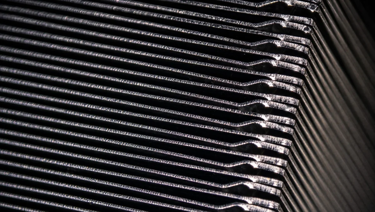 Close-up of a metallic heatsink with parallel cooling fins.