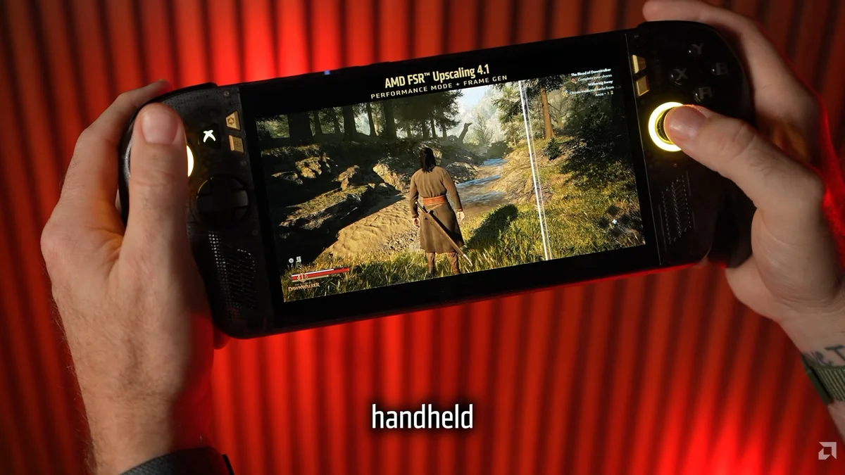 A person holds a handheld gaming device displaying a character exploring a forest in a game with 'AMD FSR™ Upscaling 4.1' and 'PERFORMANCE MODE + FRAME GEN' text visible on the screen.