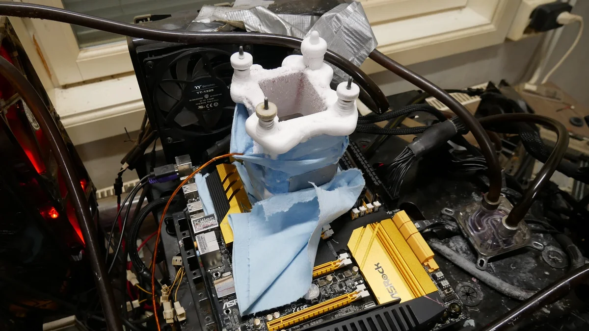 An ASRock motherboard setup with a custom liquid nitrogen cooling system and a Thermaltake TT-1225 fan.