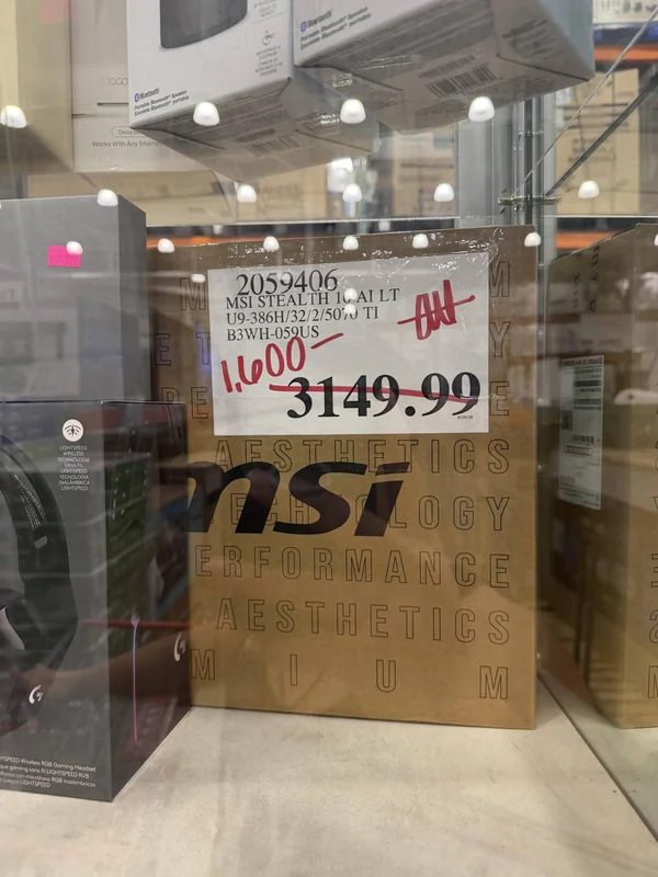 The image shows an MSI Stealth 16 AI LT with a price tag of $3149.99, marked down to $1600, displayed in a store with additional packaging in the background.