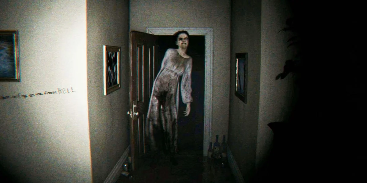 A ghostly figure stands in a dark hallway from the game P.T. with the words 'from HELL' visible on the wall.